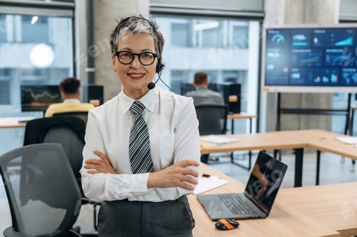 Preview: Confident businesswoman with headset smiling in modern office environment, showcasing teamwork and p