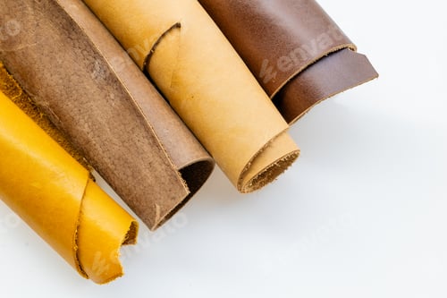 Preview: Multiple Rolled Leather Hides in Tan Brown and Yellow Tones on White Background