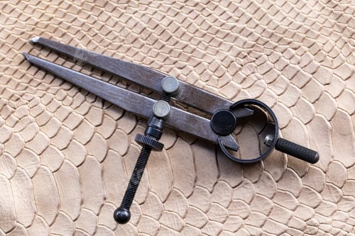 Preview: Leatherworking tools, compass and materials for artisanal design.