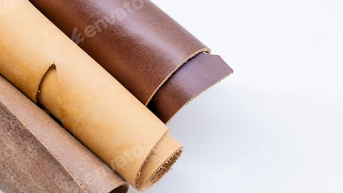 Preview: Title: Three Rolled Leather Hides in Natural Tan and Brown Tones on White Background