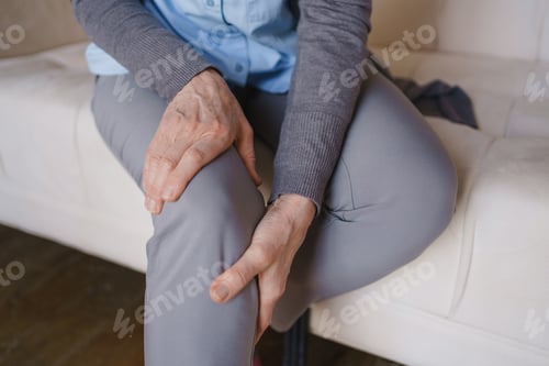 Preview: Senior woman holding sore knee in close up, elderly joint pain, arthritis symptom, mobility problem