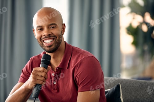 Preview: Portrait, podcaster and man with mic on couch, creative and happy for content creation in apartment