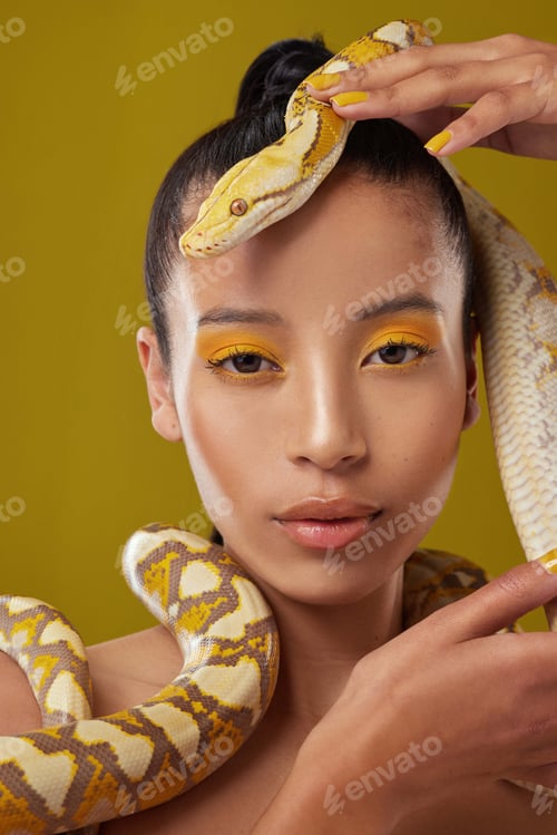 Preview: Woman, portrait or makeup with snake in studio for beauty cosmetics on a yellow background