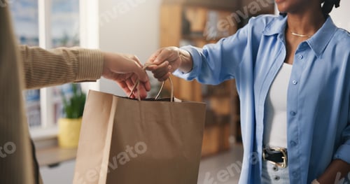 Preview: Hands, paper bag and people in boutique, employee and discount deal with purchase