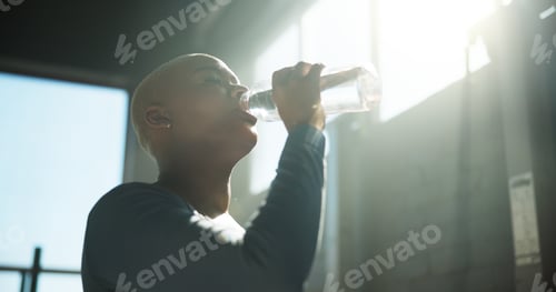 Preview: Woman, fitness and drinking with water bottle for hydration, recovery or break in gym
