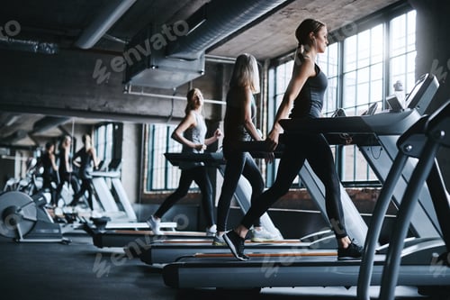 Preview: Woman, workout and earphones in gym with treadmill, cardio training and music playlist for wellness