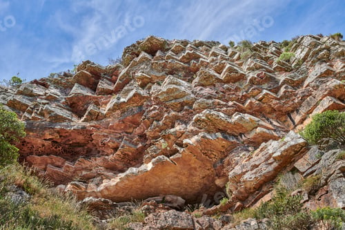 Preview: Mountain, rocks and blue sky with plants below of natural growth, environment or wilderness