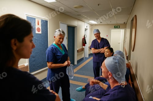 Preview: Conversation, meeting and PPE with surgeon team in hospital hallway for medical consulting