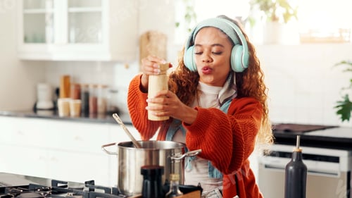 Preview: Cooking, music and seasoning with woman in kitchen of home for flavor, food or meal preparation