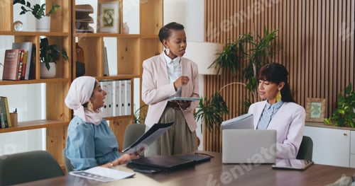 Preview: Woman, tablet and documents with team in office meeting for strategy, laptop