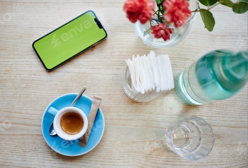 Preview: Top view of coffee cup, smartphone with blank green screen and cafe table setting
