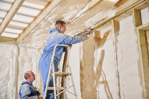 Preview: Two workers insulating timber frame house with polyurethane foam spray