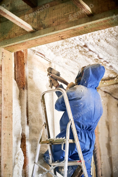 Preview: Installer covering wall cavity near roofline with expanding foam insulation in new house