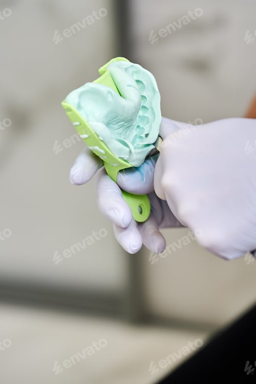 Preview: Professional dentist cutting out teeth imprint.