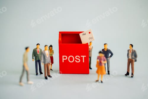 Preview: Miniature figures gathered around a red post box with a letter being dropped inside, showcasing a po