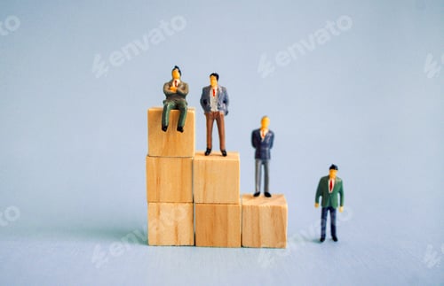Preview: Miniature figurines of business professionals standing on wooden blocks, representing growth and suc