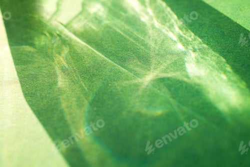 Preview: Abstract close-up of green textured surface with light reflections creating patterns, showcasing vib