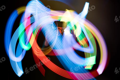 Preview: Abstract light trails created by a person spinning LED lights in a dark environment, vibrant colors