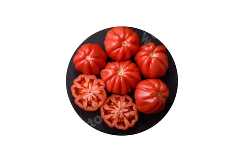 Preview: Fresh pink heirloom ribbed tomatoes as an ingredient for a lunch salad. Ribbed heirloom tomatoes