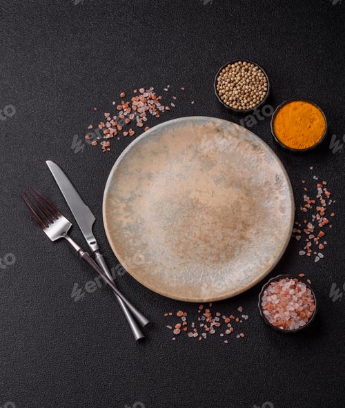 Preview: An empty ceramic round plate, kitchen utensils for a dinner table. An empty plate