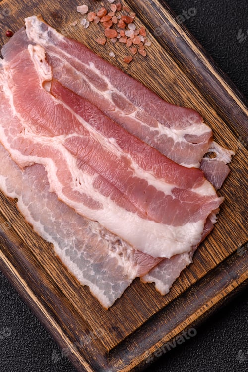 Preview: Raw fresh bacon slices with layers of meat or prosciutto with salt and spices. Raw bacon