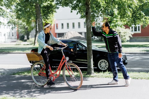Preview: Man gestures angrily toward woman riding red bicycle on sidewalk, suggesting conflict in shared urba