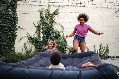 Preview: Young adults and children jumping on inflatable mattress