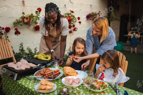 Preview: Multi ethnic happy family enjoying outdoor backyard barbecue party