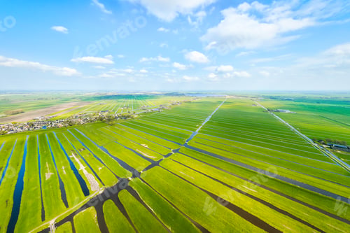 Preview: Aerial view of Dutch agricultural landscape with green fields, meadows and water canals.
