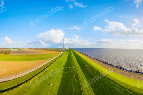 Preview: Aerial view of wind turbines on green fields near sea coast and dam. Scenic landscape.