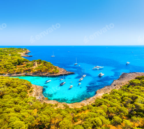 Preview: Aerial view of luxury yachts and boats anchored in a turquoise bay with crystal clear water on the c