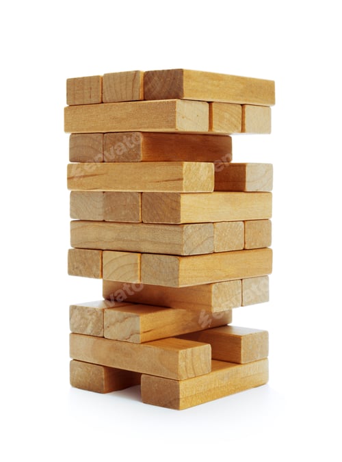 Preview: Wooden blocks are stacked in a tall tower on a white background by a builder during daytime