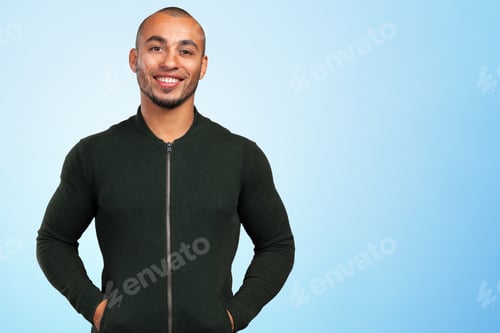Preview: Man stands and smiles in front of a blue background
