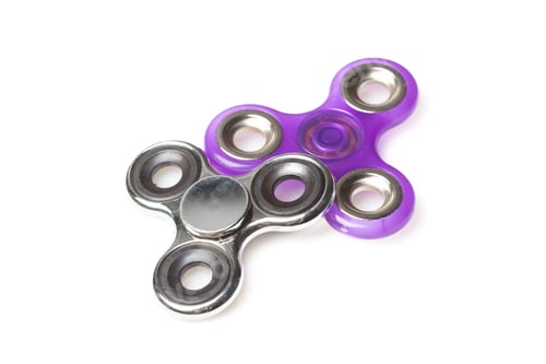 Preview: Fidget spinner in silver and purple colors placed on a white surface
