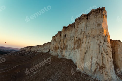 Preview: Mountains rise above the valley during sunset near the white cliffs in a clear sky