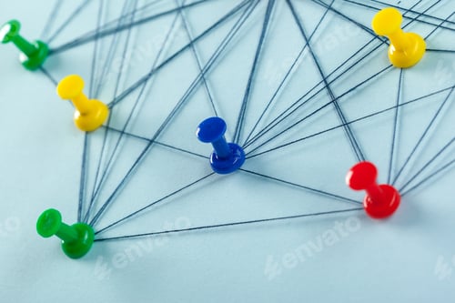 Preview: Colorful push pins connected by thread on a blue background show a network map in action