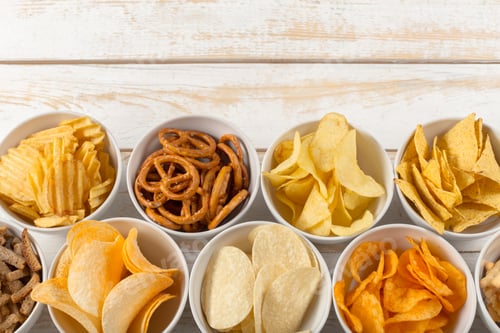 Preview: Various snacks are arranged in bowls on a wooden surface for sharing during a social gathering