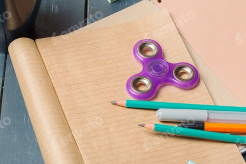 Preview: Stationary items on a table with a fidget spinner, pencils, and a notepad