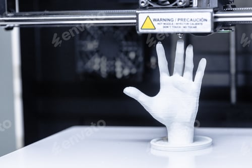 Preview: 3D printer creates a white hand model in a workshop during daytime hours