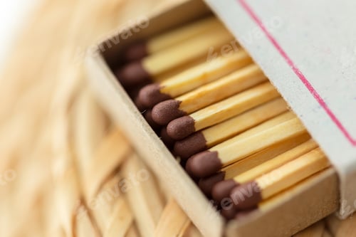 Preview: Matchsticks in a small cardboard box placed on a woven surface