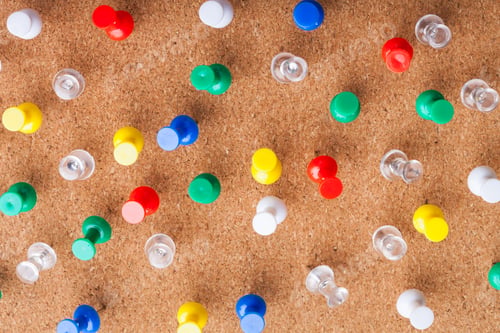 Preview: Colorful push pins scattered on a cork board for organization and display