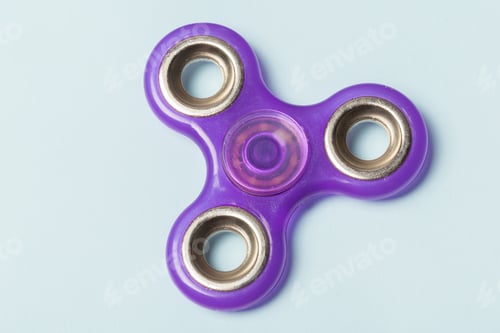 Preview: Fidget spinner sits on a light blue background during a calm afternoon
