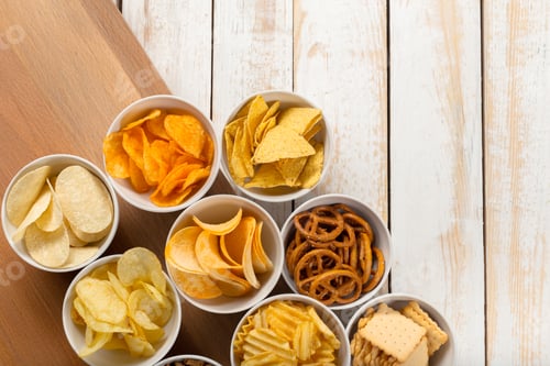 Preview: Different kinds of snacks arranged in bowls on a wooden surface