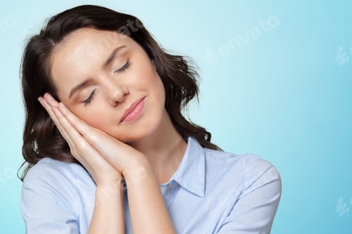 Preview: Woman resting her head on her hands while smiling against a blue background