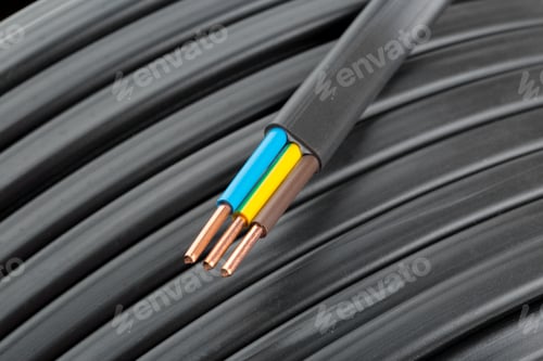 Preview: Copper wires are arranged in a spool with insulation for electrical projects in a workshop