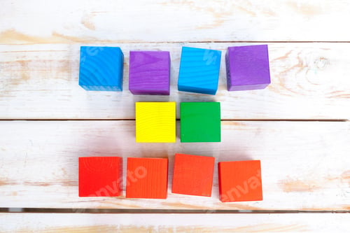 Preview: Colorful wooden blocks arranged on a wooden surface during daytime playtime