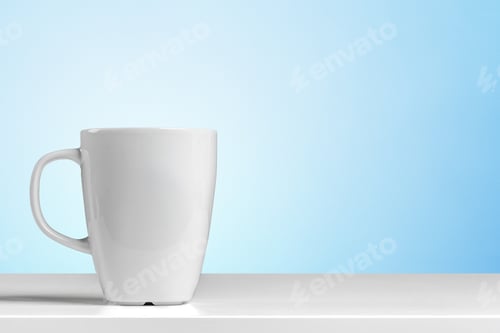 Preview: Cup placed on a white surface with a light blue background during daytime