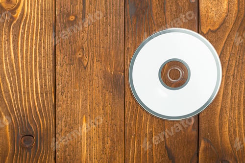 Preview: Blank CD on wooden table with natural texture showing light and shadow