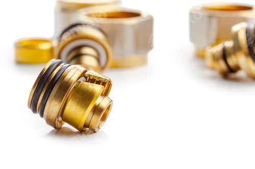 Preview: Various metal fittings and connectors on a white surface with focus on one piece