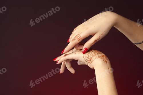 Preview: Hands with henna designs and red nail polish show cultural expression in art